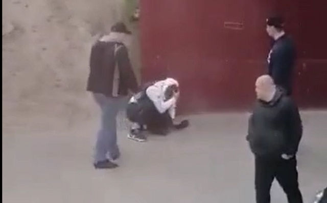 Видео: полицейский наблюдает, как насколько человек избивают мужчину, СК начал проверку